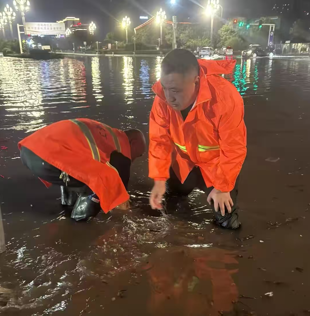 1758494132158.png 神州环境副总经理孔凡超带领环卫团队在雨中疏通下水道口.png